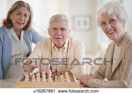 Stock Image - Senior adults playing chess. Fotosearch
