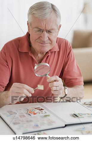 Senior man looking at stamp collection View Large Photo Image Stock Photograph - Senior man looking at stamp collection. Fotosearch