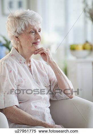 Stock Photography - Senior woman sitting on sofa. Fotosearch