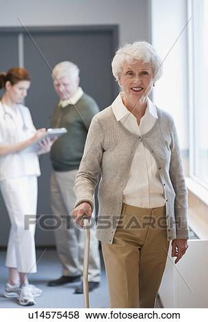 Stock Photo - Senior woman walking with cane. Fotosearch