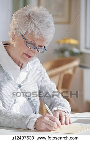 Stock Image - Senior woman writing letter. Fotosearch