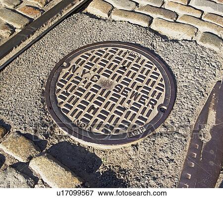 Sewer cover on urban street View Large Photo Image Stock Photo - Sewer cover on urban street. Fotosearch
