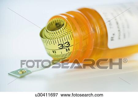 Stock Photo - Tape measure in prescription bottle. Fotosearch