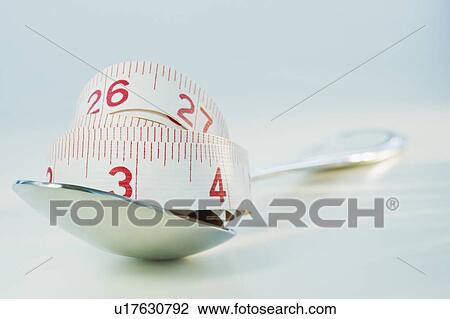 Stock Image - Tape measure on spoon. Fotosearch