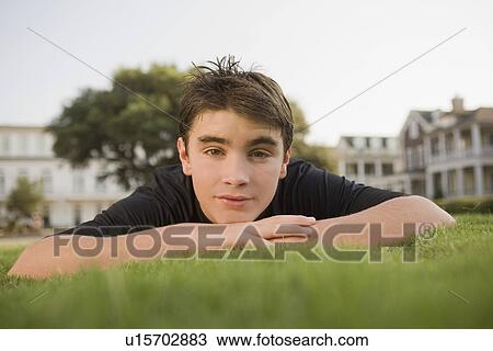 Stock Image - Teenage boy in grass. Fotosearch
