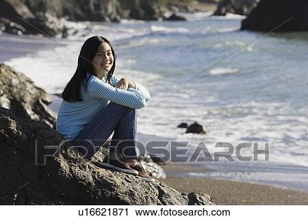 Teenage girl sitting on coastal rock View Large Photo Image Stock Image - Teenage girl sitting on coastal rock. Fotosearch