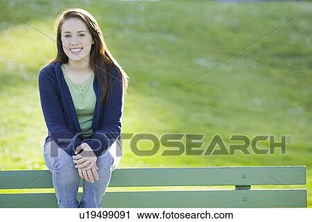Teenage girl sitting on park bench View Large Photo Image Stock Image - Teenage girl sitting on park bench. Fotosearch
