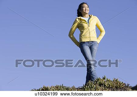 Teenage girl standing on hill View Large Photo Image Stock Photo - Teenage girl standing on hill. Fotosearch