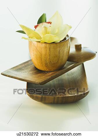 Stock Image - Tropical flower and wooden bowls. Fotosearch