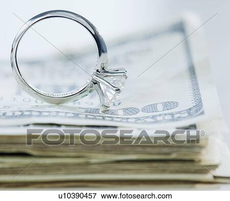 Stock Photo - Wedding cake toppers on stack of cash. Fotosearch