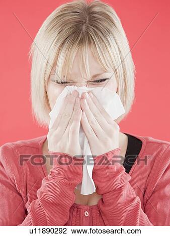 Stock Image - Woman blowing nose. Fotosearch