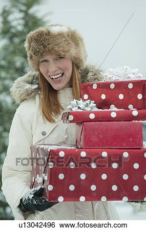 Stock Photograph - Woman carrying Christmas gifts. Fotosearch