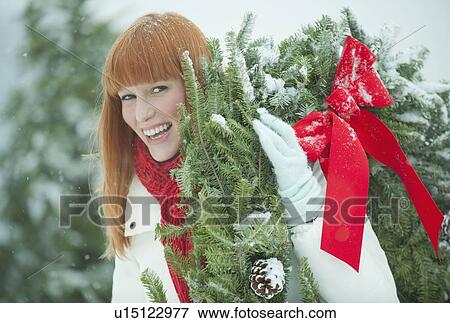 Woman carrying Christmas wreath View Large Photo Image Stock Photo - Woman carrying Christmas wreath. Fotosearch