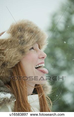 Woman catching snow on tongue View Large Photo Image Stock Photo - Woman catching snow on tongue. Fotosearch