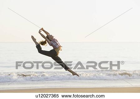 Stock Photography - Woman dancing on beach. Fotosearch