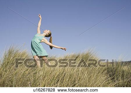 Stock Photo - Woman dancing on sand dunes. Fotosearch