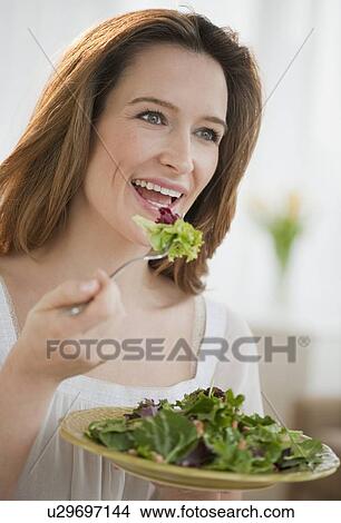 Picture - Woman eating salad. Fotosearch