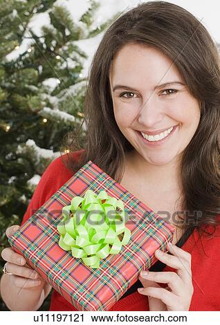 Woman holding Christmas gift View Large Photo Image Stock Image - Woman holding Christmas gift. Fotosearch