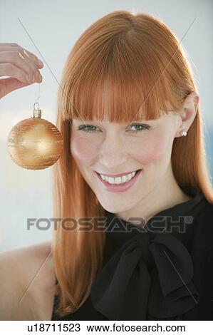 Woman holding Christmas ornament View Large Photo Image Stock Image - Woman holding Christmas ornament. Fotosearch