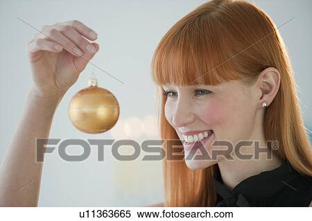 Woman holding Christmas ornament View Large Photo Image Stock Photography - Woman holding Christmas ornament. Fotosearch