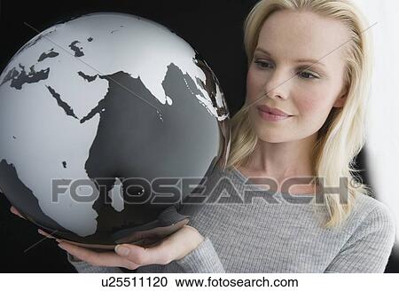 Stock Image - Woman holding modern globe. Fotosearch