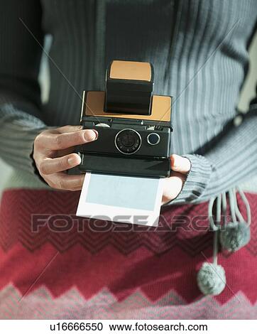Stock Image - Woman holding vintage camera. Fotosearch