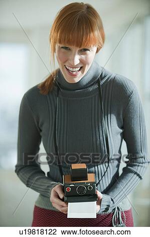 Stock Image - Woman holding vintage camera. Fotosearch