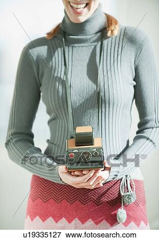 Stock Photo - Woman holding vintage camera. Fotosearch