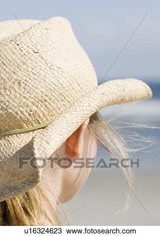 Stock Image - Woman in cowboy hat on beach. Fotosearch
