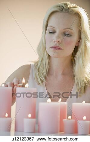 Stock Photo - Woman lighting candles. Fotosearch
