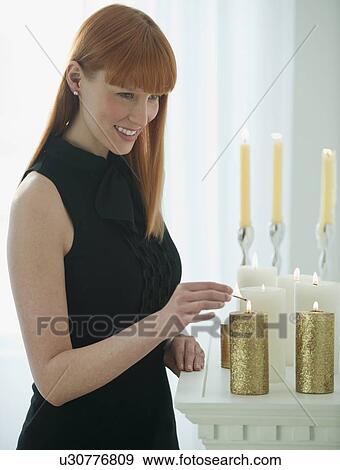 Woman lighting holiday candles View Large Photo Image Stock Photo - Woman lighting holiday candles. Fotosearch