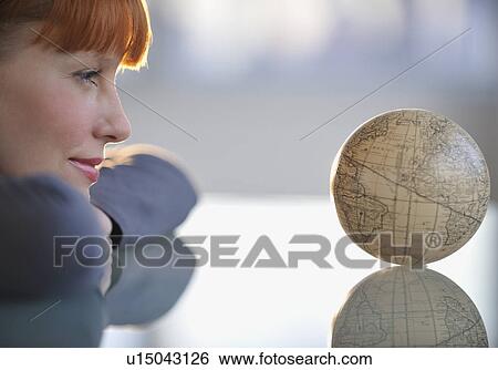 Stock Photograph - Woman looking at globe. Fotosearch
