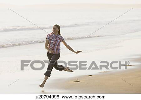 Stock Photograph - Woman running on beach. Fotosearch