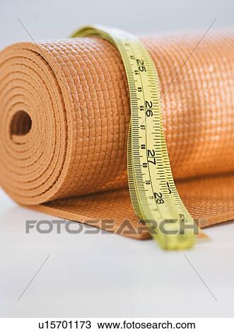 Stock Image - Yoga mat and tape measure. Fotosearch