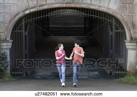 Stock Image - Young couple running through tunnel. Fotosearch