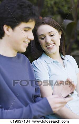 Picture - Young couple sitting on park bench. Fotosearch