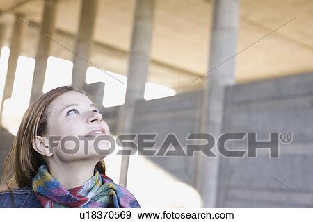 Young woman looking up View Large Photo Image Stock Photo - Young woman looking up. Fotosearch