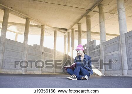 Young woman reading in urban setting View Large Photo Image Stock Photo - Young woman reading in urban setting. Fotosearch