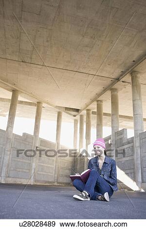 Young woman reading in urban setting View Large Photo Image Stock Photo - Young woman reading in urban setting. Fotosearch