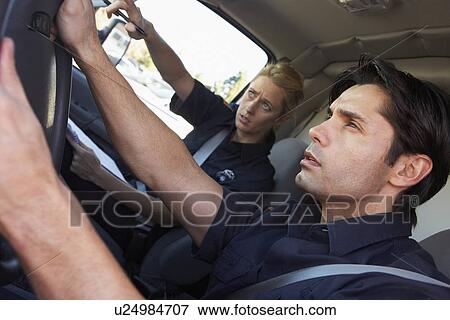 Stock Photo - Ambulance driver and colleague on the way to an emergency. Fotosearch