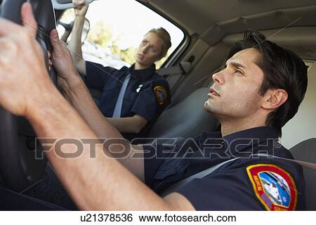 Ambulance driver and colleague on the way to an emergency View Large Photo Image Stock Photograph - Ambulance driver and colleague on the way to an emergency. Fotosearch