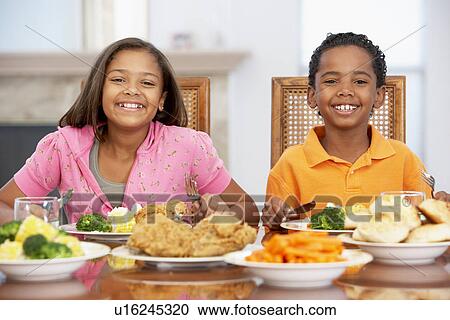Stock Image - Brother And Sister Having Lunch Together At Home. Fotosearch