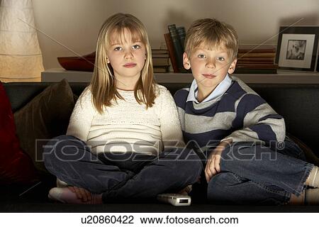 Stock Image - Brother And Sister Watching Television. Fotosearch