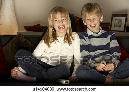 Stock Photo - Brother And Sister Watching Television. Fotosearch