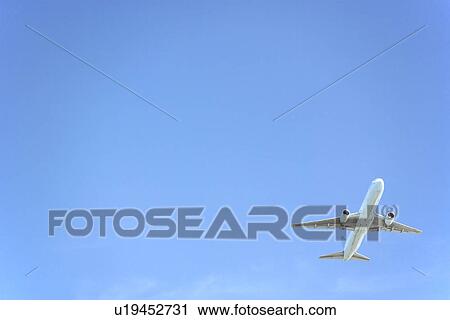 Commercial Airplane Flying Against A Blue Sky View Large Photo Image Stock Image - Commercial Airplane Flying Against A Blue Sky. Fotosearch