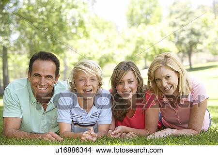 Couple And Their Teenage Children Lying On Grass View Large Photo Image Picture - Couple And Their Teenage Children Lying On Grass. Fotosearch