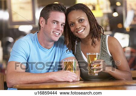 Picture - Couple Drinking Beer Together In A Pub. Fotosearch