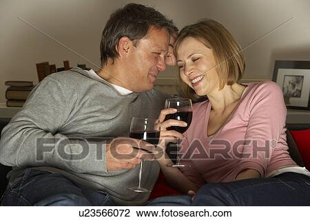 Stock Image - Couple Drinking Wine And Not Watching Television. Fotosearch