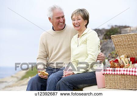 Couple Eating An Al Fresco Meal At The Beach View Large Photo Image Stock Photo - Couple Eating An Al Fresco Meal At The Beach. Fotosearch