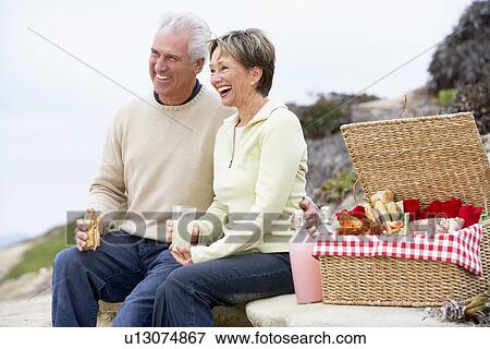 Stock Photo - Couple Eating An Al Fresco Meal At The Beach. Fotosearch